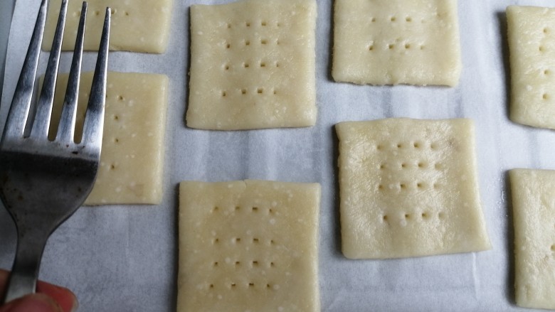 咸味土豆饼干,移到铺了油纸的烤盘上,用叉子叉出多个小孔