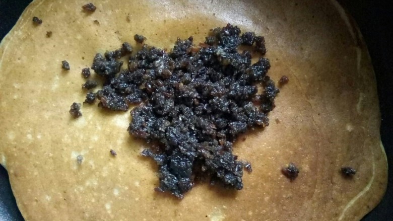 幸福西饼,重舀面糊摊平，烙好翻面，放黑芝麻红豆馅。