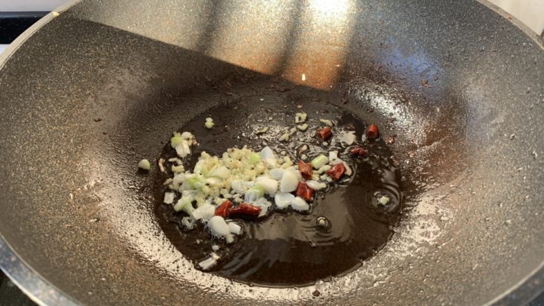 鸡肉片炒洋葱,热锅凉油放入葱姜蒜和干辣椒,炒出香味。