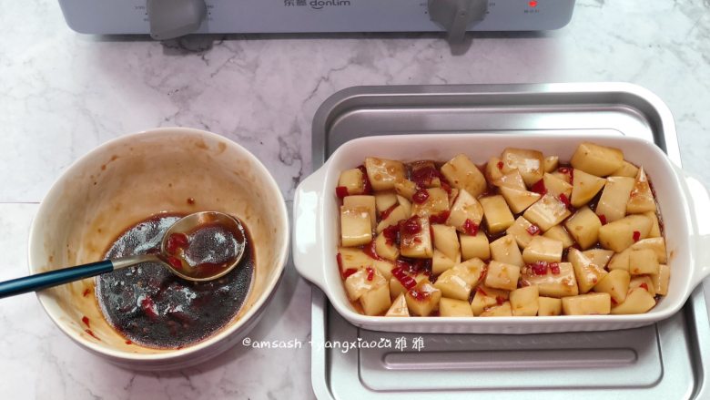 烤土豆,把土豆平铺好装进烤盘中,腌制的时候有剩的酱汁备用着