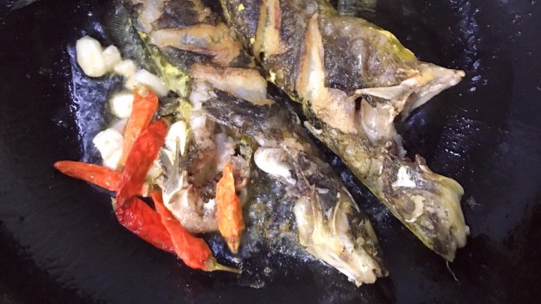 黄骨鱼土豆汤,鱼两面都微焦后把鱼拨至一边,放入大蒜,生姜和<a style='color:red;display:inline-block;' href='/shicai/ 86474'>干辣椒</a>,炒出香味
