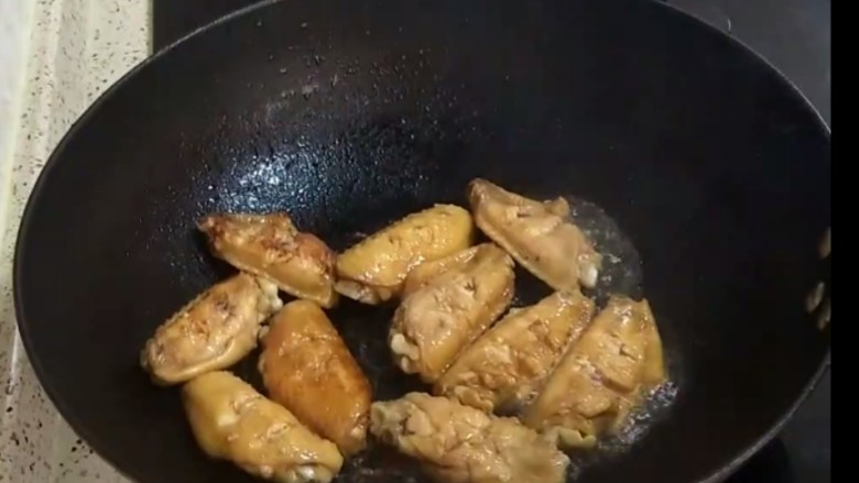 香煎鸡翅,锅烧热后,加入两勺花生油,放入腌制好的鸡翅,小火煎
