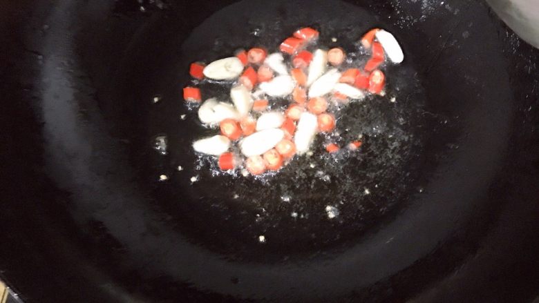 油焖茭白,热锅放油,倒入大蒜和小米辣炒香
