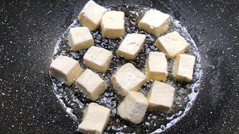 杂蔬豆腐,锅里放入适量油烧热,把裹好淀粉的豆腐放到锅里煎至六面金黄,煎好夹入盘里待用。