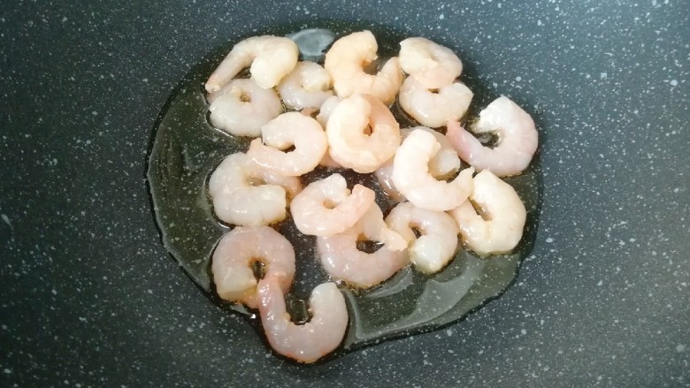 甜豆红萝卜炒虾仁,炒锅内倒适量的食用油烧热,下入腌制好的虾仁。