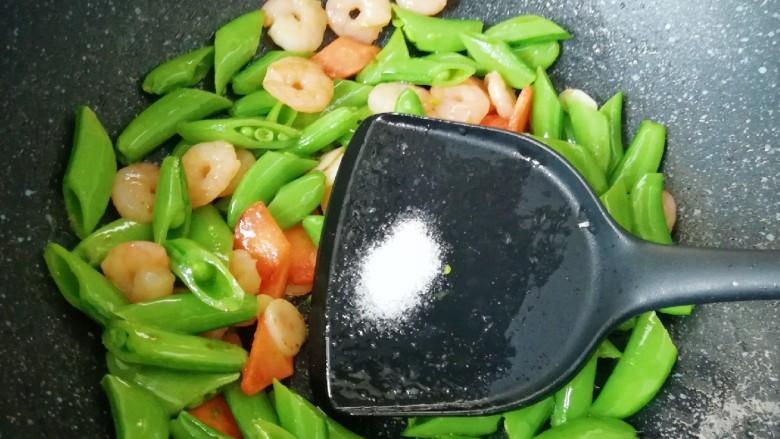 甜豆红萝卜炒虾仁,放盐调味,翻炒均匀即可。