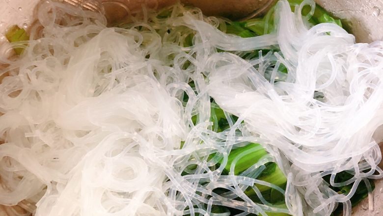 凉拌小白菜粉丝,把粉丝跟小白菜放凉拌盆里,粉丝绞断