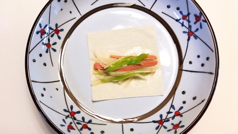 蔬菜卷,取一个馄饨皮,在馄饨皮上加入炒好的青菜