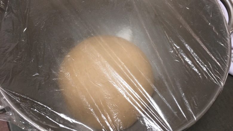 葡萄干黑麦面包,拿出整理滚圆,放入桶里盖上保鲜膜。