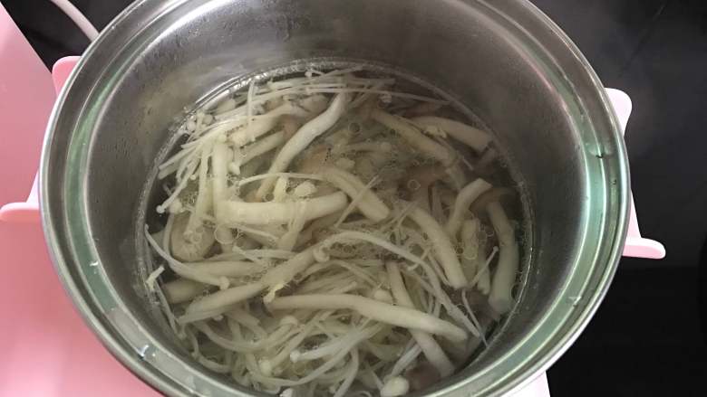 鸡蛋菌菇汤,煮锅中加入适量水,煮开后把焯过水的蟹味菇和金针放入锅中。
