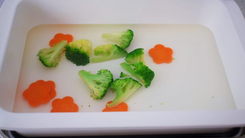 照烧鸡腿饭,锅中烧开水,加入少许盐和食用油,再放入胡萝卜和西兰花焯水一分钟后