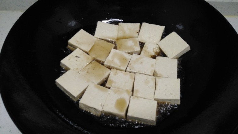 西红柿炒豆腐、西葫芦,锅中放入适量油,油热后放入豆腐。