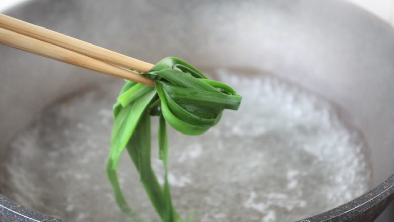 春日包菜饭便当,韭菜焯水,焯水后过凉水,沥干水分备用。