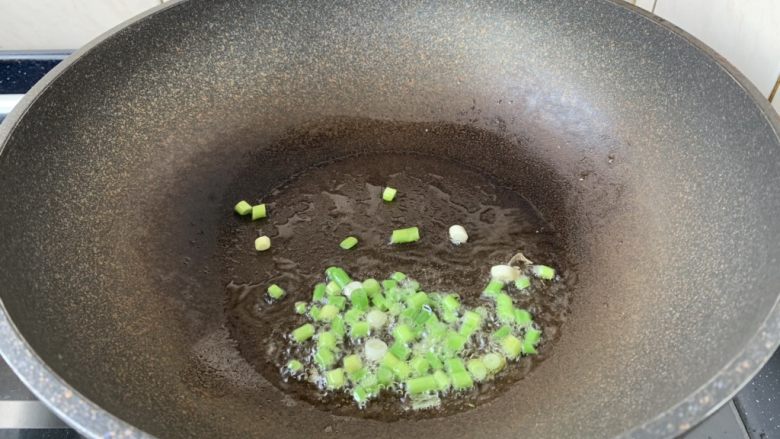 春日包菜饭便当,热锅凉油,放入葱花,炒出香味。