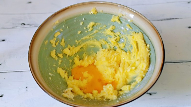 咖啡豆饼干,分两次加入全蛋液,继续启动电动打蛋器,打至蛋液与黄油完全融合。