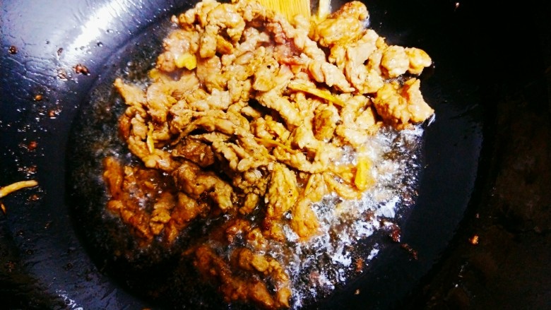 肉丝黄花菜,锅中倒油,油热后倒去腌制的肉丝,翻炒