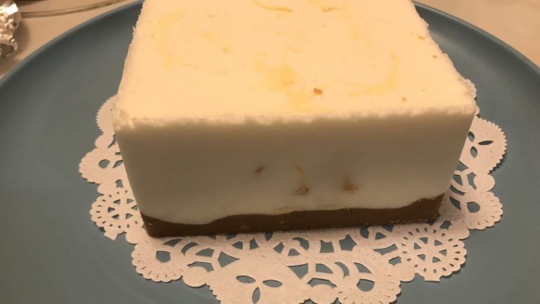 酸奶芒果蛋糕,取出模具。(技巧:热毛巾敷敷,先掰开上部边缘,更容易脱落,下部往上顶,让饼干泥脱模,最后轻轻往下推)