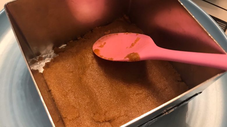 酸奶芒果蛋糕,饼干泥放入包好锡纸的底部,压实压平,冷藏15分钟以上。