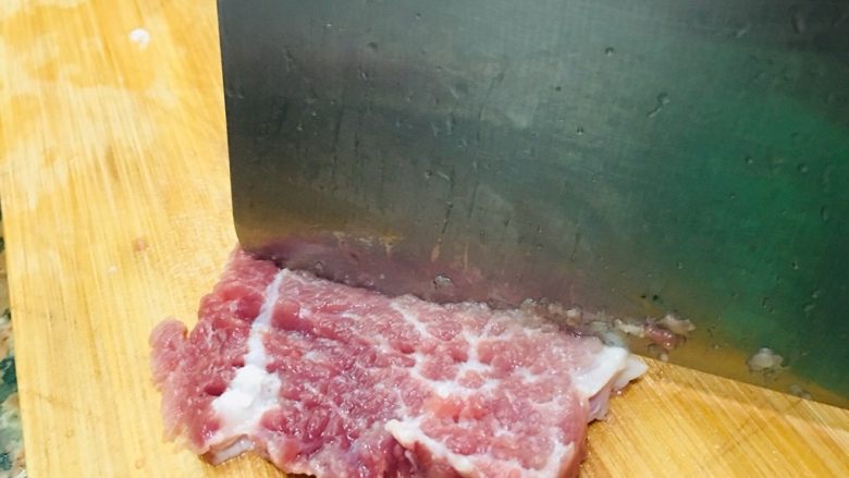烤箱版酥香猪排,瘦肉切片,用刀背敲一遍。