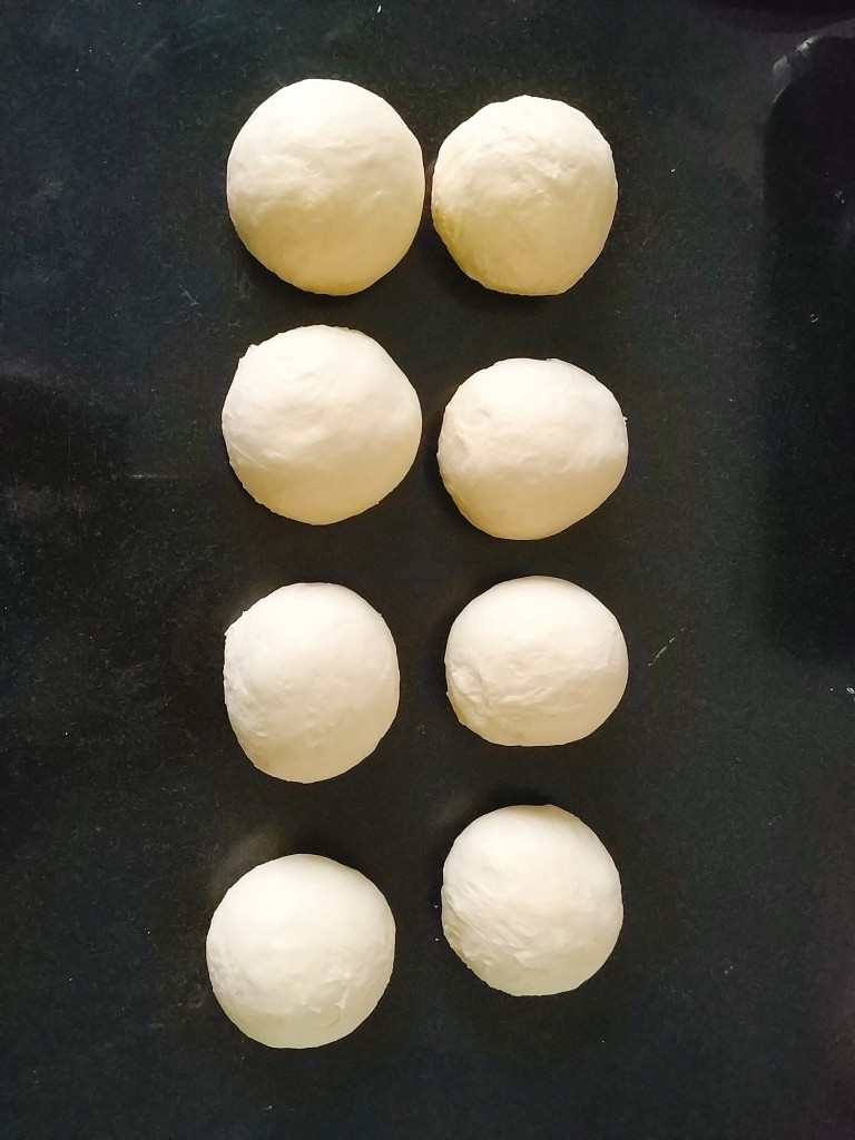 椰蓉心形面包,把发酵好的面团放在操作台上,用手轻压排气,平均分成6-8份,分别揉圆,盖保鲜膜室温静置松弛10分钟;
按自己喜欢的大小就可以,我喜欢小点的,分的8份;