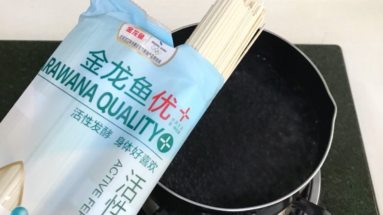 酸辣凉拌面,锅内倒入适量的清水烧开,把金龙鱼活性空心挂面放入锅中。