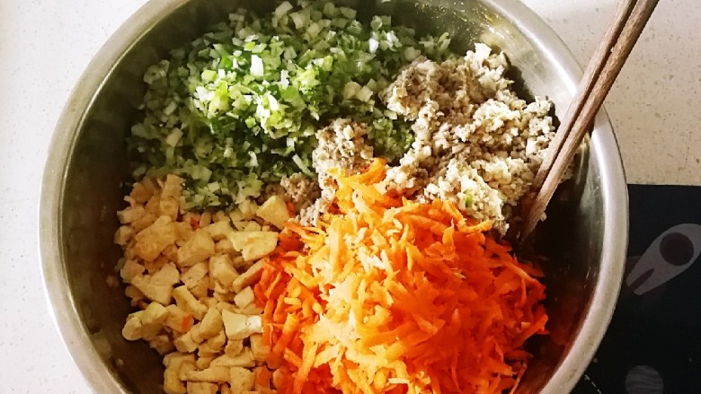 野菜豆腐包子,葱切碎 胡萝卜擦丝 煎好的豆腐丁 切碎的蘑菇丁 一同放入搅拌好的肉糜上