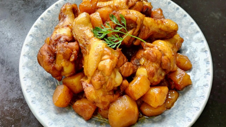 红烧土豆鸡翅根,装盘,放上香菜叶点缀