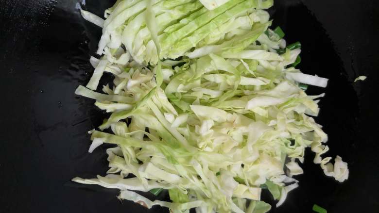 素炒粉丝卷心菜,加入卷心菜翻炒,这个时候最好用筷子来帮助翻炒,更容易使蔬菜同时成熟。