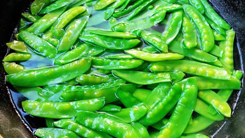 蒜蓉荷兰豆,锅中烧开水放入荷兰豆焯水时间不要过长变色全部漂浮上来即可,可以加一点点食用碱这样荷兰豆颜色更加翠绿