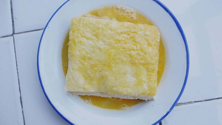 家常西多士,鸡蛋打散成蛋液倒入盘中(方便沾在吐司表面)均匀沾满一层蛋液
