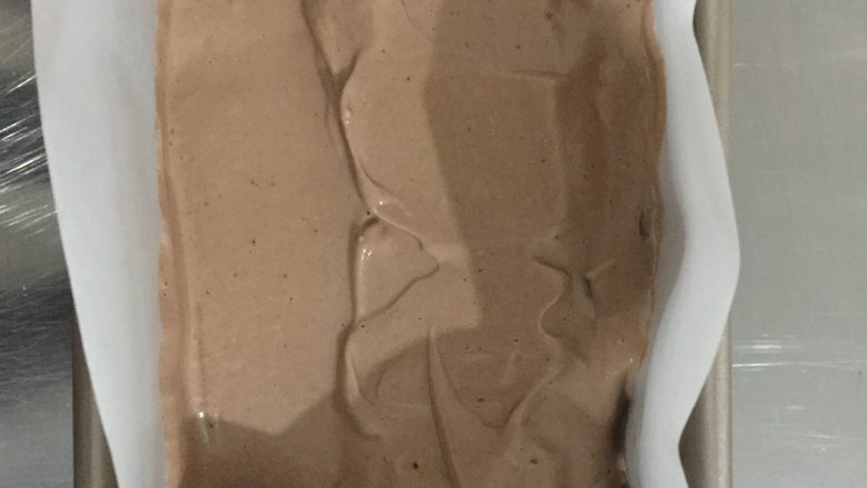 可可蛋糕吐司,把可可蛋糕糊装入发酵好的吐司中(吐司模具要加油纸),约150g每份,表面做好抹平一点点。