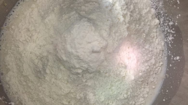 可可蛋糕吐司,把中种面团的材料放入酵母牛奶液中,厨师机开中速把面粉搅拌成团。