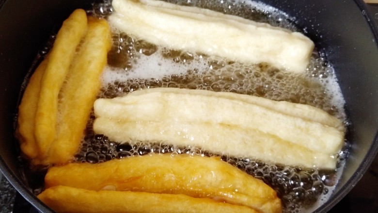 简单快手炸油条,先来炸大油条,把锅里油烧热,放入油条炸制,