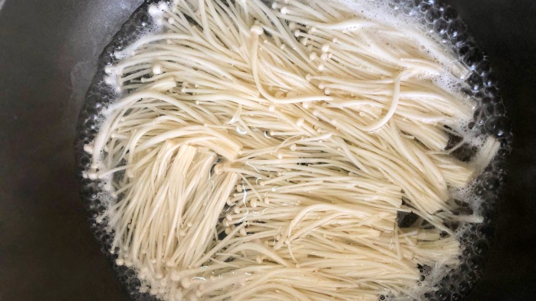 金针菇豆腐,起锅烧水,放入金针菇煮八分熟。