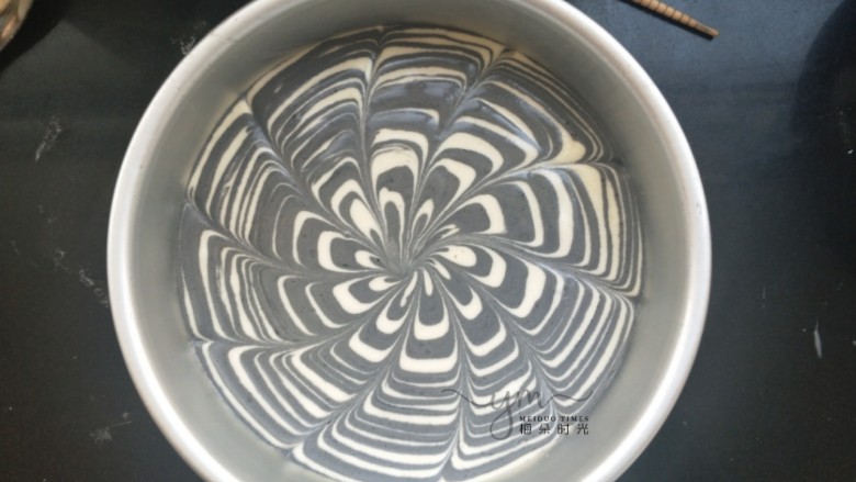 斑马纹戚风蛋糕,用一根筷子从外向中心划线,拉出漂亮花纹。也可以不拉花。然后放进预热好的烤箱,上下火,140度。烤50分钟。每个烤箱温度不一样,根据自己的烤箱性能习惯调整时间。