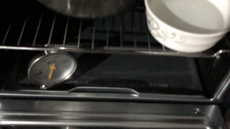 自制豆沙包,放在温暖湿润的地方发酵半个小时。我这里放进烤箱里,旁边放了一碗热水。