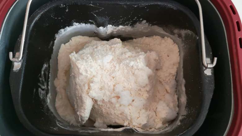 好吃又好看的椰蓉葡萄干吐司,将以上这些原料(黄油除外),按时先液体后粉类的顺序倒入面包桶中,用面包机将其和成面团。