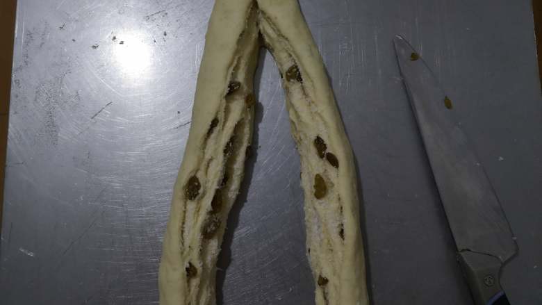 好吃又好看的椰蓉葡萄干吐司,卷好后,用刀将面团分割开,顶部最好不要切断。
