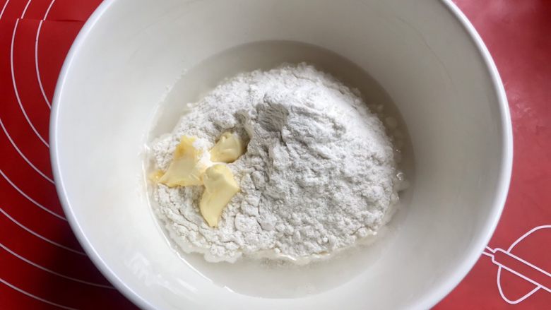 蔓越莓糯米馅老婆饼,开始做水油皮,把面粉,糖,水,黄油放入大碗里。