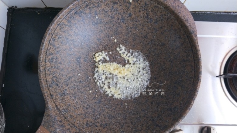 荷塘小炒,炒锅内倒油,把蒜末炒黄炒香。