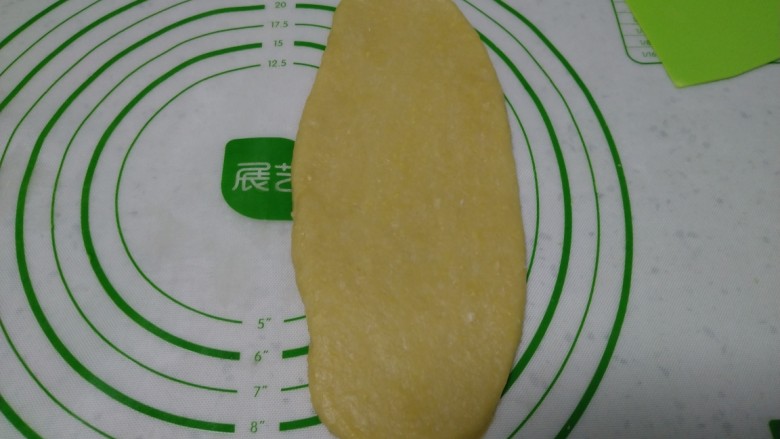 蒸葡萄干面包,取一个面团,擀成牛舌状。