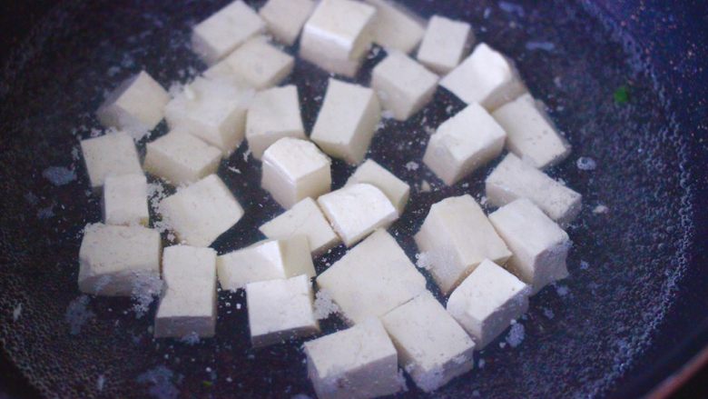 双椒烩双色豆腐,锅中加入清水大火烧开,放入豆腐进行焯水,煮一分钟捞出即可。