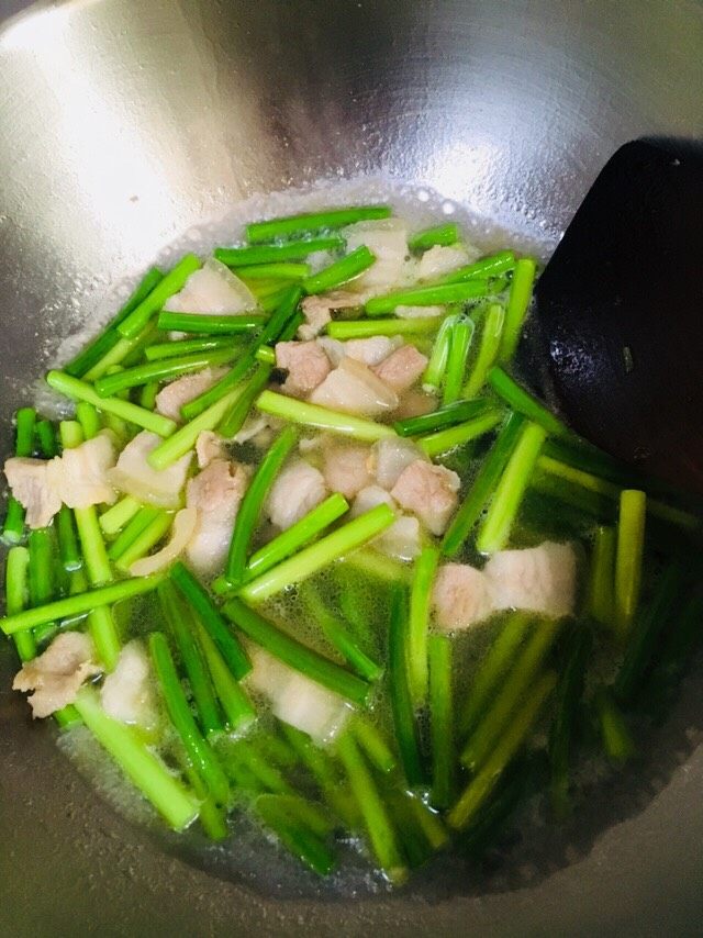 蒜苔炒肉,大火翻炒3一5分钟,接着放入少许热水