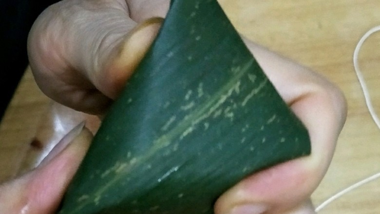 彩色三角粽,包的时候用拇指和食指压住两边,把上面的叶子往下压