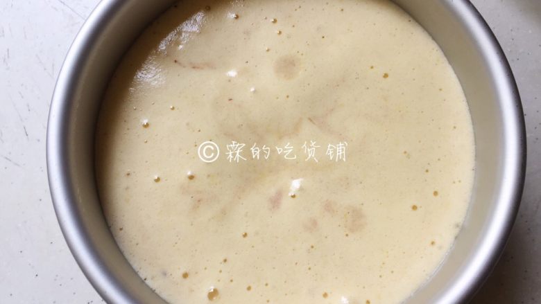 蜜红豆小米蒸蛋糕,把拌好的蛋糕糊倒入六寸蛋糕模中,用力震几下,把里面的大气泡震出来。