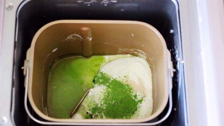 双色菠菜花样馒头,把剩下的110克中筋面粉和2克酵母,5克白砂糖和2克<a style='color:red;display:inline-block;' href='/shicai/ 84307'>菠菜粉</a>都倒入面包桶里,再加入称重的清水,启动和面程序开始和面。