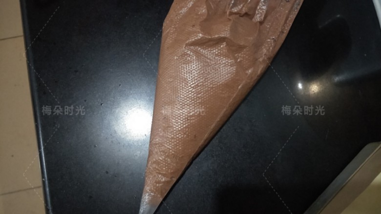 可可旋风蛋糕卷,可可面糊倒进裱花袋里面,剪一个小口。