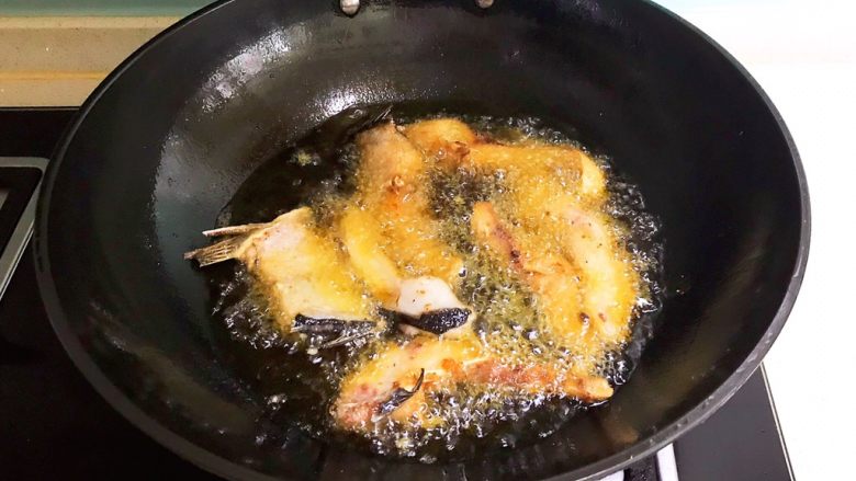 红烧鱼块,待油温降至7分热的时候加入鱼段,小火炸至两面金黄