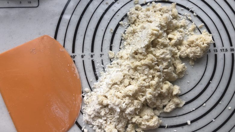 萌趣【红豆包心酥】,倒到操作台上用手和刮板按压成团。