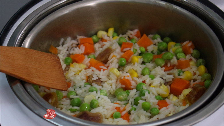 蔬菜腊肠饭,将锅中的米饭连同米汤倒入脱糖饭煲中,用木铲拌均匀